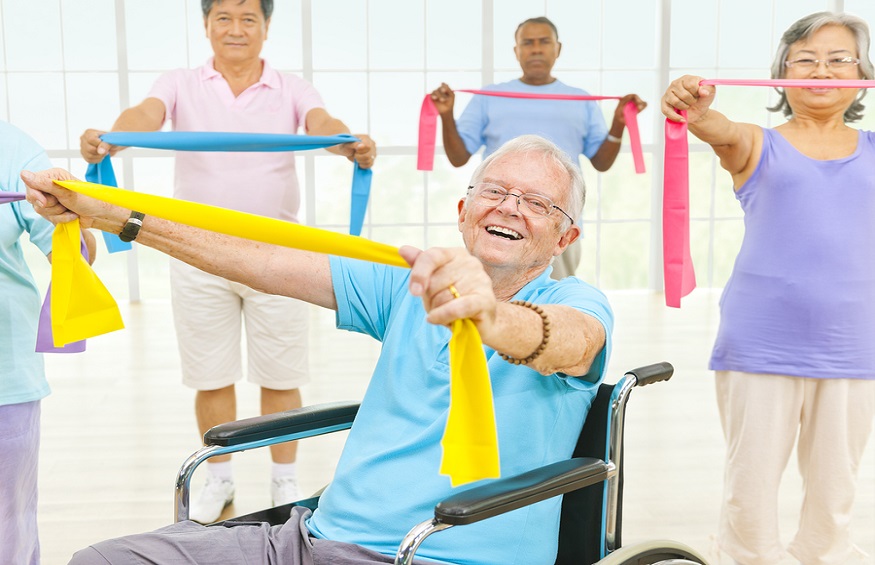 Mature Adults and a Disabled Person Exercising in a Gym